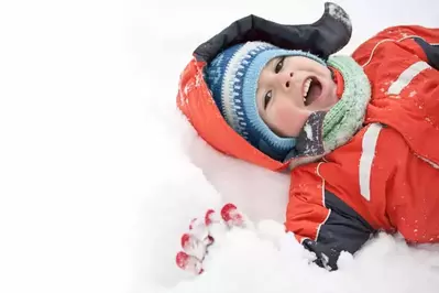 happy boy laying in snow