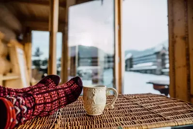 Person lounging with their socks at a cozy cabin