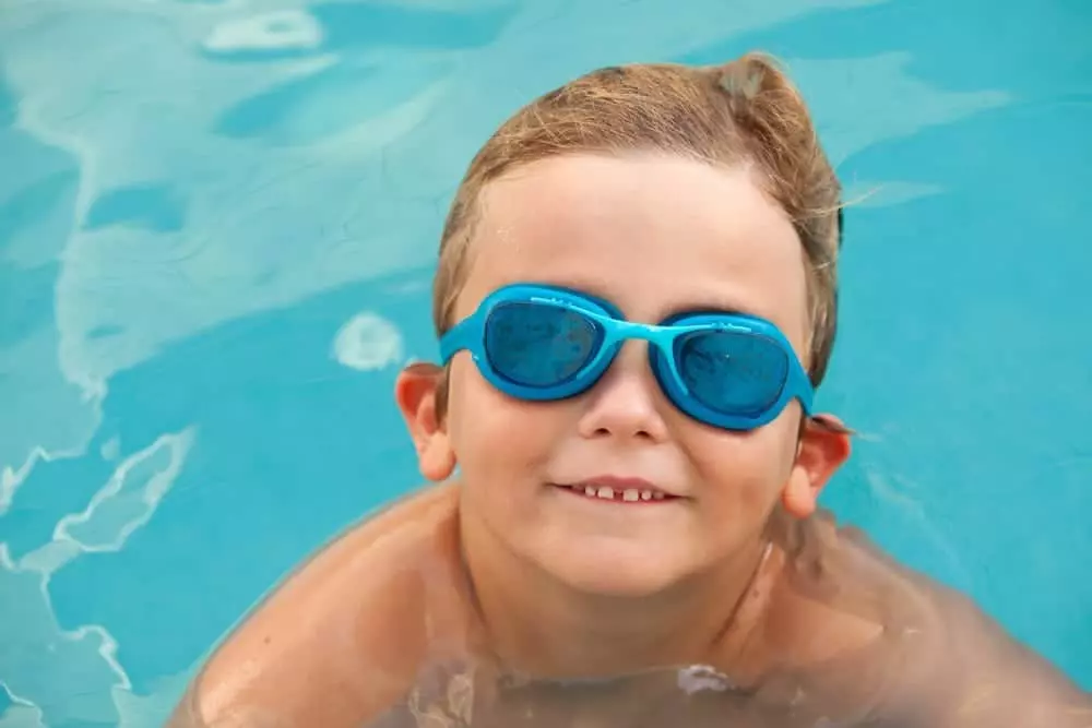 smiling little boy with blue goggles in pool at Smoky Mountain cabin