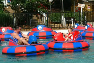 man and child having fun on blaster boats at Bear Country Fun Park