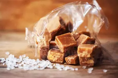 A bag of salted caramels on a wooden table.