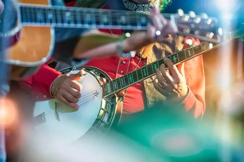 A banjo player with a guitarist in front of him.