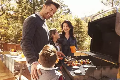 Family having a cookout on a deck.