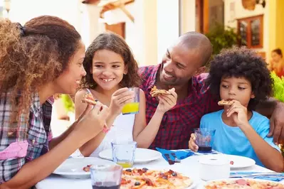 A family eating pizza together at a restaurant.