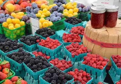 Berries, other fruits, and mason jars at a farmers market.