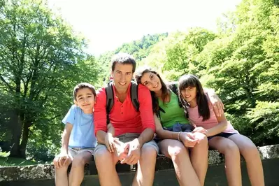 A family resting on a bridge in the mountains.