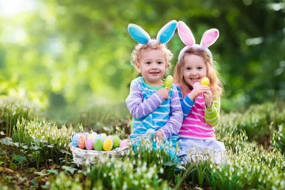 Little girls with Easter eggs and rabbit ears in the grass near our Great Smoky Mountain cabins.