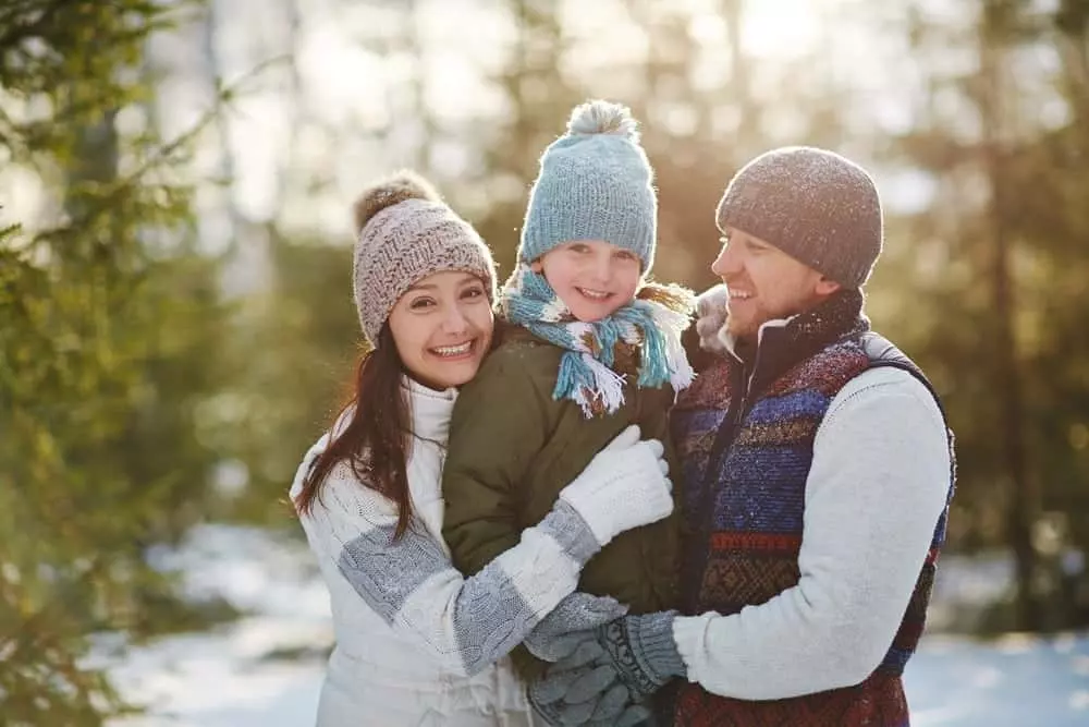 Happy family of three enjoying the snow outside of our Great Smoky Mountain vacation rentals.