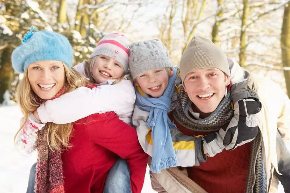 Happy family outside on a winter day outside of our Pigeon Forge Tennessee log cabins.