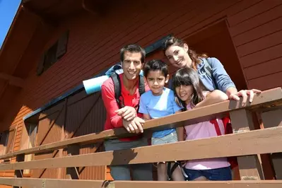 Happy family on the porch of a vacation rental near Gatlinburg TN.