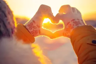 Two hands making a heart shaping the sun in Gatlinburg