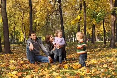 Family playing outside in the fall leaves