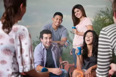 Family drinking beverages outside and laughing together