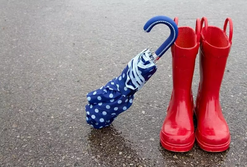 Red rain boots and an umbrella outside