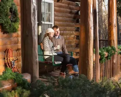 Couple smiling on the porch of a cabin