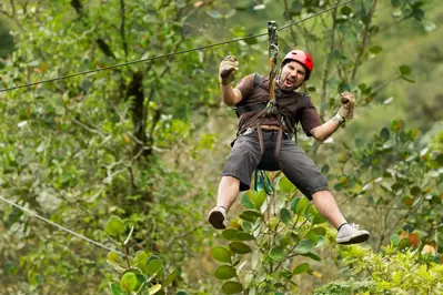 Man zip lining through the woods