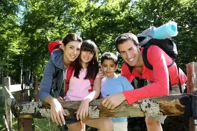 Family resting from hike on fence