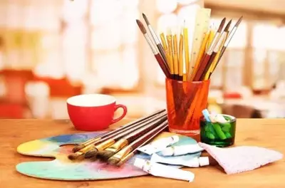 Pencils, brushes, and watercolors on table for arts and crafts